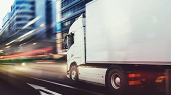 White truck moving fast on the road in a modern city with light effect